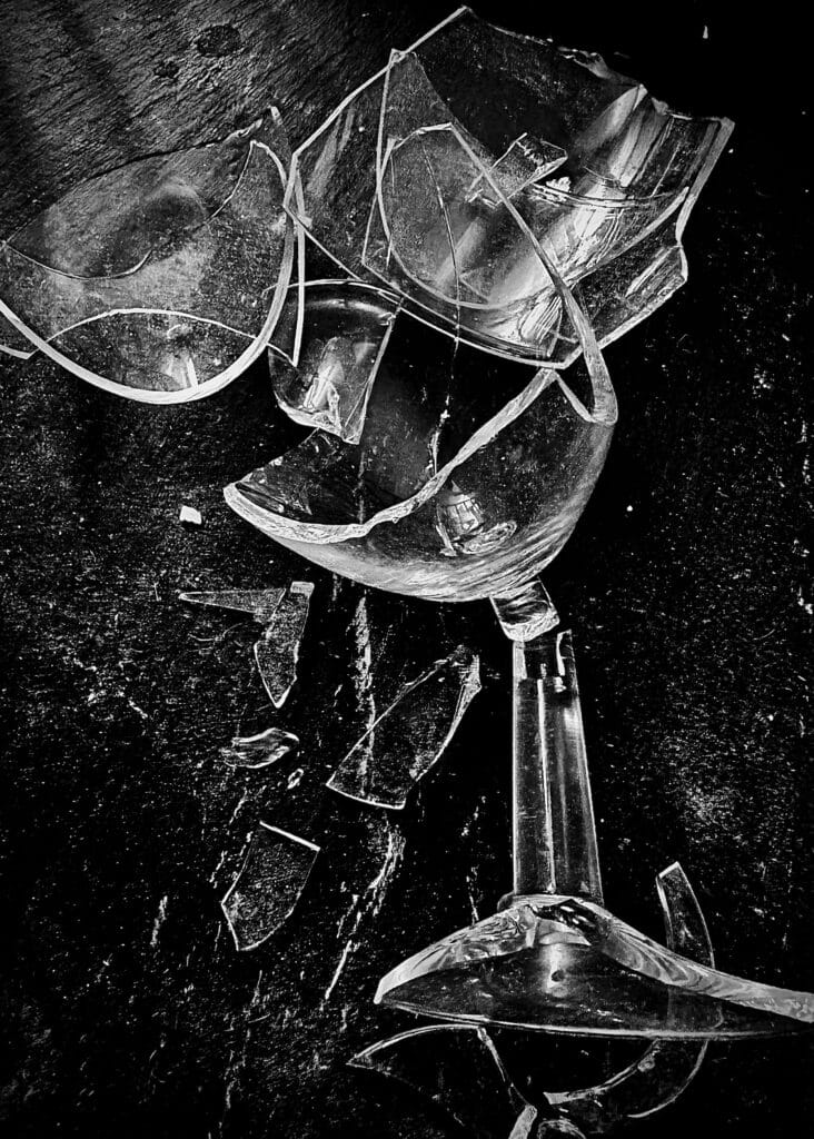 A broken wine glass with sunlight streaming through, symbolising breaking free from addiction. Sobriety vs. Recovery: The Truth About Healing and Moving Forward