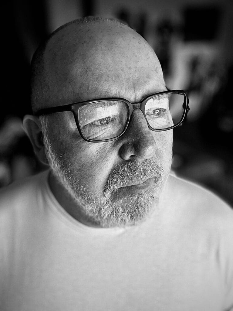 Middle-aged man with glasses in deep reflection, black and white portrait symbolising personal transformation and sobriety change your life after 45